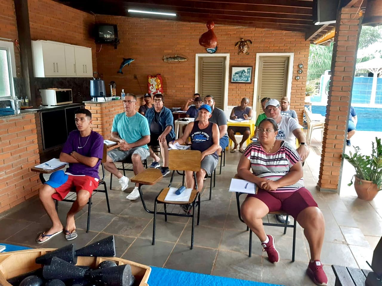 Aula teórica da Escola Náutica, com os alunos acompanhando a apostila